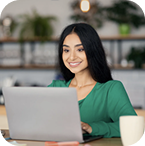 Smiling female professional working on laptop, representing life with discreet Invisalign Aligners.